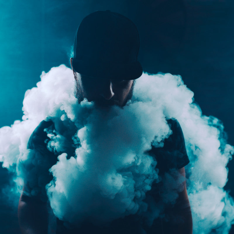 Mann umgeben von Dampf, symbolisiert den Unterschied zwischen Vape und Vaporizer.