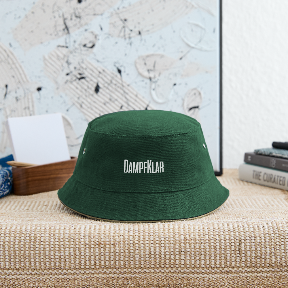 Grüner Bucket Hat mit DAMPFKLAR-Logo auf einem stilvollen Tisch, ideal für Kinder und modisch gestaltet.